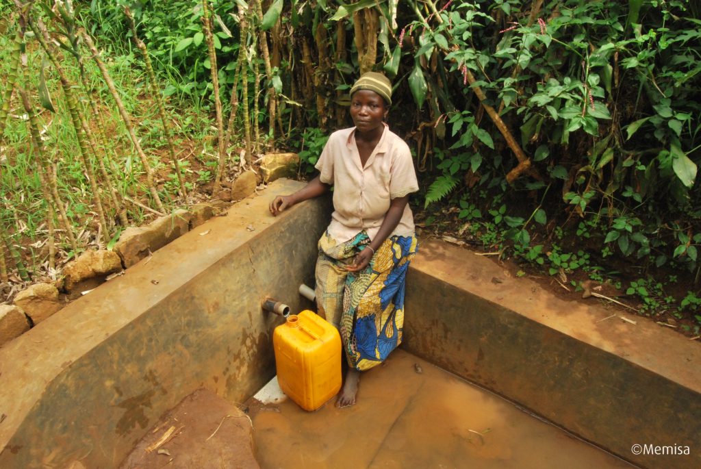 Au Sud-Kivu, une femme remplit son bidon d'eau à une source