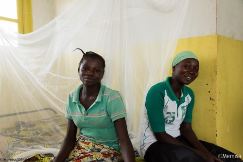 2 femmes assises sur un lit avec moustiquaire, centre de santé en RD du Congo