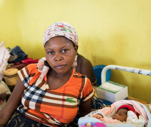 femme assise sur un lit d'hôpital avec son bébé