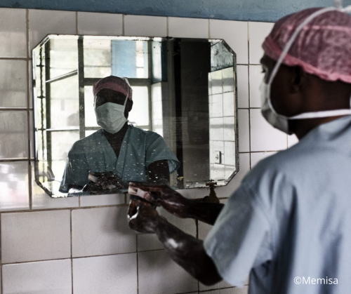 personnel médical en blouse, masque et bonnet de protection se lave les mains 